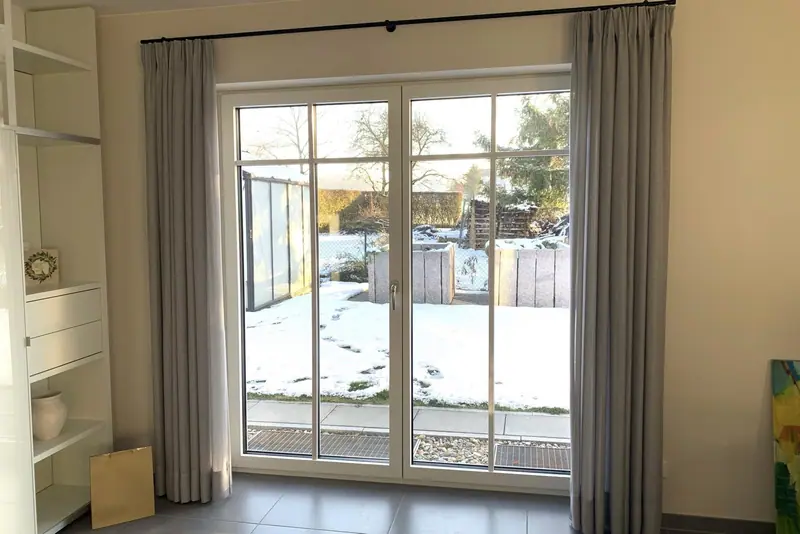 Zweiflügelige Fenstertür mit Sprossen in einem hellen Wohnraum